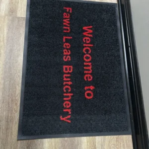 Branded jet print mat with Fawn Leas Butchery logo in red on a dark mat