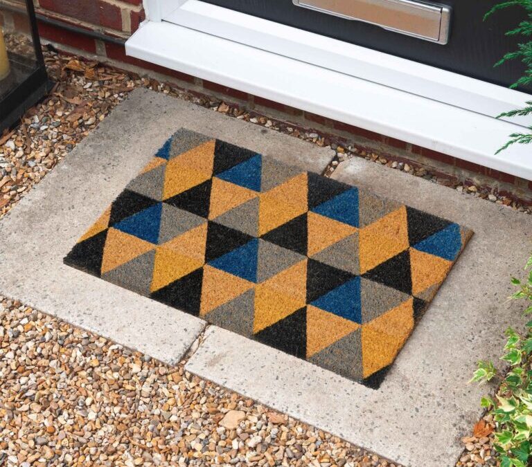 Geometric-pattern outdoor doormat placed at a front door entrance