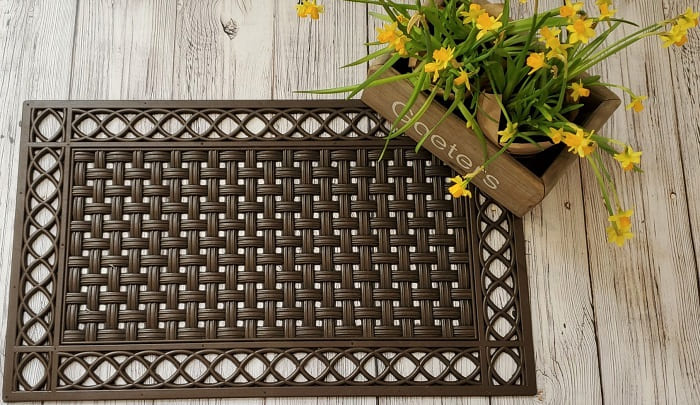 Woven rubber doormat on wooden floor