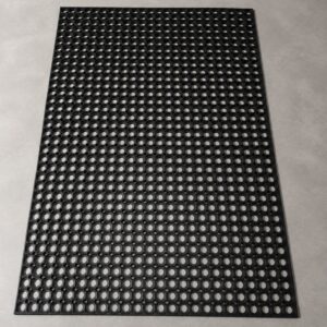 Black workplace safety ring mat for anti-fatigue, drainage and slip-resistant flooring in industrial work areas.